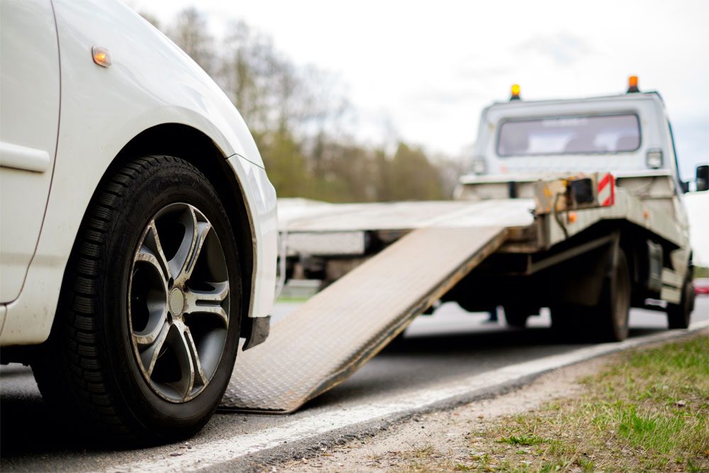 Gilbert-Blog-Rental-Car-Reimbursement-Coverage-Featured-Image Photo of a car about to be loaded onto the tow truck