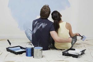 Photo of a couple painting an interior wall - Links to home insurance page