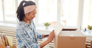 Image of a young woman packing a cardboard box
