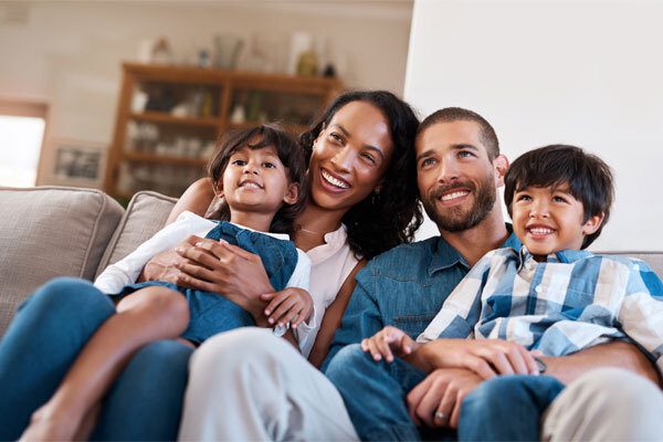 Image of a family sitting on the living room sofa, very happy